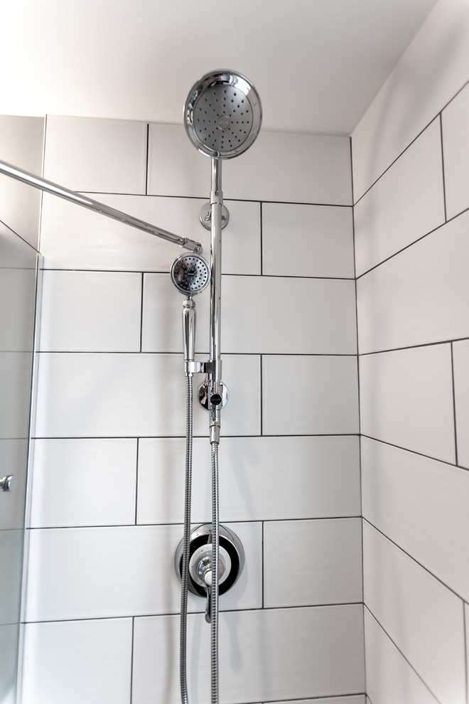 Photo of a small classic shower room bathroom in Minneapolis with a built-in shower, a wall mounted toilet, white tiles, ceramic tiles, blue walls, porcelain flooring, a submerged sink, recycled glass worktops, white floors, a hinged door and grey worktops.