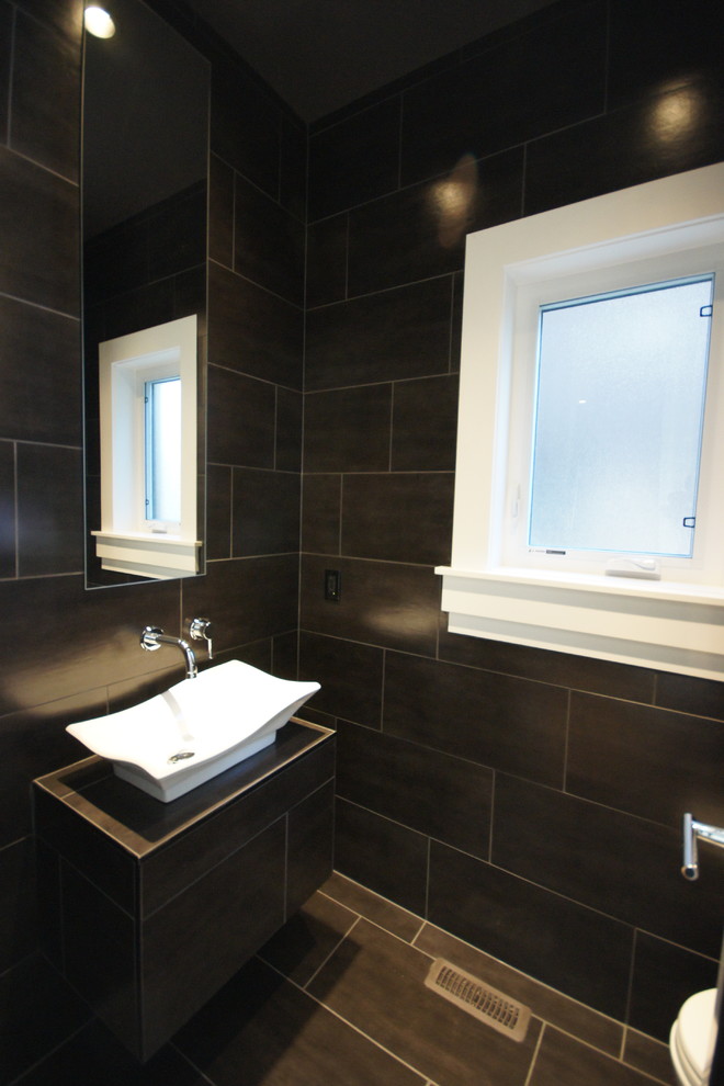 Example of a trendy black tile bathroom design in Calgary with a vessel sink