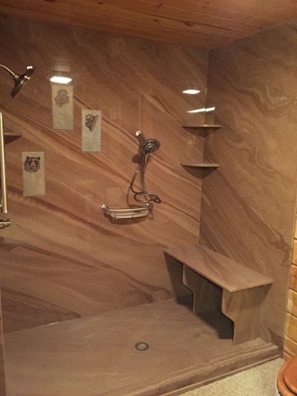 Modelo de cuarto de baño rural con ducha empotrada, baldosas y/o azulejos marrones, losas de piedra y paredes marrones