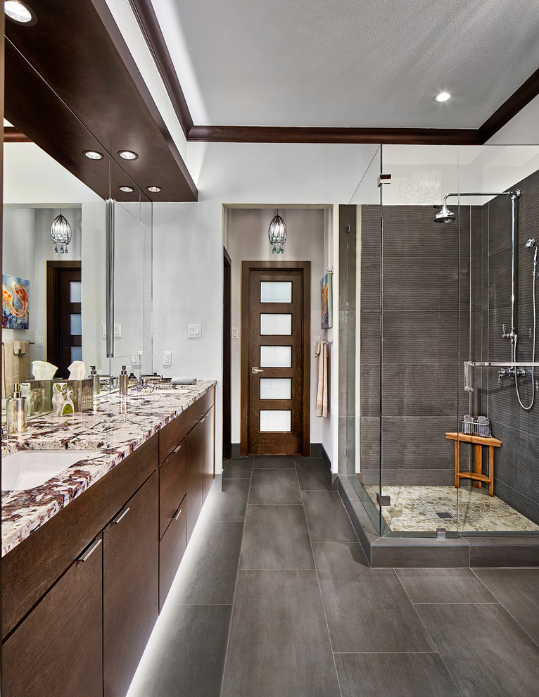 This is an example of a medium sized traditional ensuite bathroom in Dallas with flat-panel cabinets, a corner shower, grey tiles, porcelain tiles, porcelain flooring, a submerged sink, granite worktops and a hinged door.
