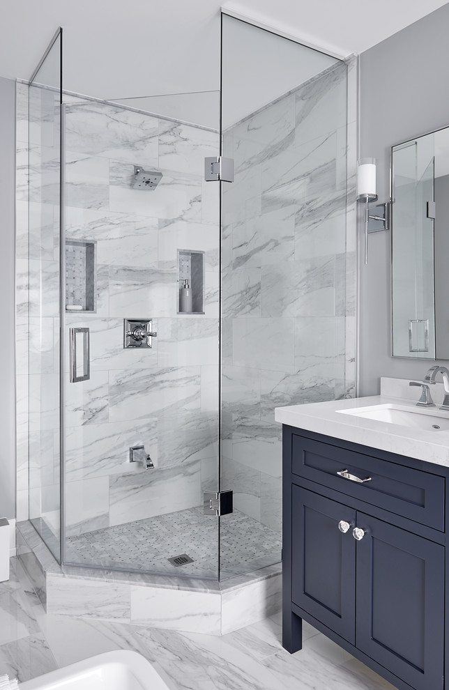На фото: ванная комната в стиле неоклассика (современная классика) с фасадами в стиле шейкер, синими фасадами, угловым душем, белой плиткой, серыми стенами, врезной раковиной, белым полом, душем с распашными дверями и белой столешницей с