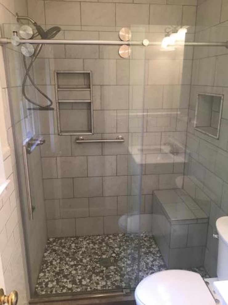 Foto på ett litet funkis badrum med dusch, med en dusch i en alkov, en toalettstol med separat cisternkåpa, grå kakel, keramikplattor, grå väggar, klinkergolv i småsten, flerfärgat golv och dusch med skjutdörr