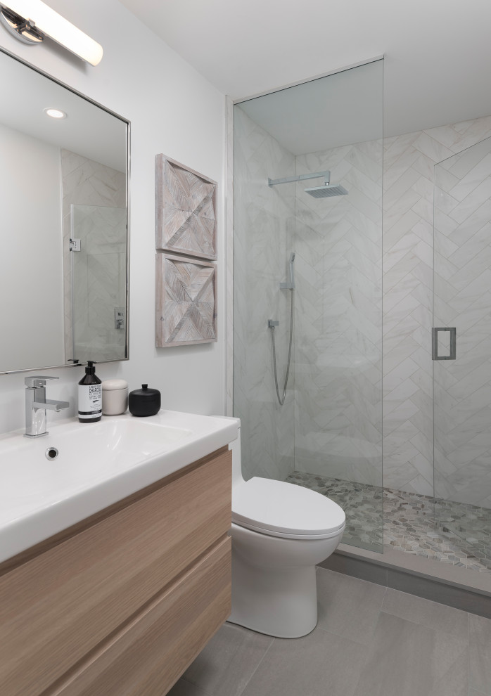 Small contemporary bathroom in Toronto with flat-panel cabinets, an alcove shower, a one-piece toilet, white tiles, porcelain tiles, white walls, porcelain flooring, an integrated sink, engineered stone worktops, grey floors, white worktops, a single sink, a floating vanity unit, light wood cabinets and a hinged door.