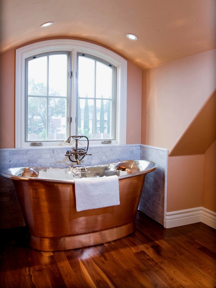 На фото: ванная комната в классическом стиле с отдельно стоящей ванной, бежевыми стенами и темным паркетным полом