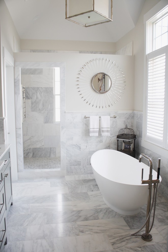Bild på ett stort vintage badrum, med luckor med infälld panel, grå skåp, ett fristående badkar, en hörndusch, vit kakel, marmorkakel, grå väggar, marmorgolv, ett nedsänkt handfat och bänkskiva i kvarts