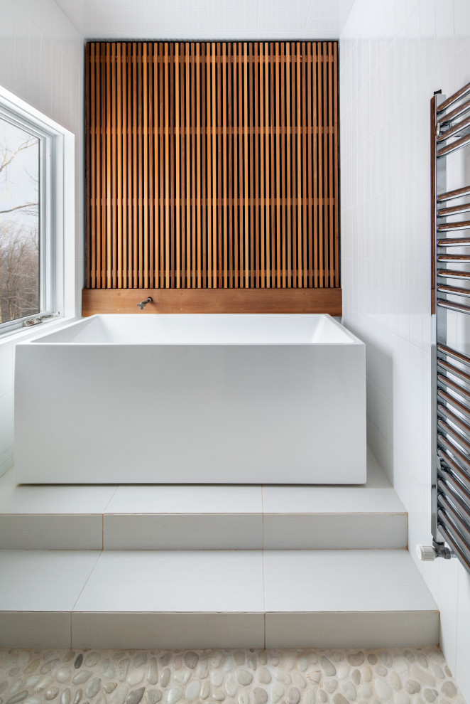 Inredning av ett modernt mellanstort en-suite badrum, med ett fristående badkar, vit kakel, våtrum, porslinskakel, vita väggar, klinkergolv i keramik, vitt golv och dusch med gångjärnsdörr