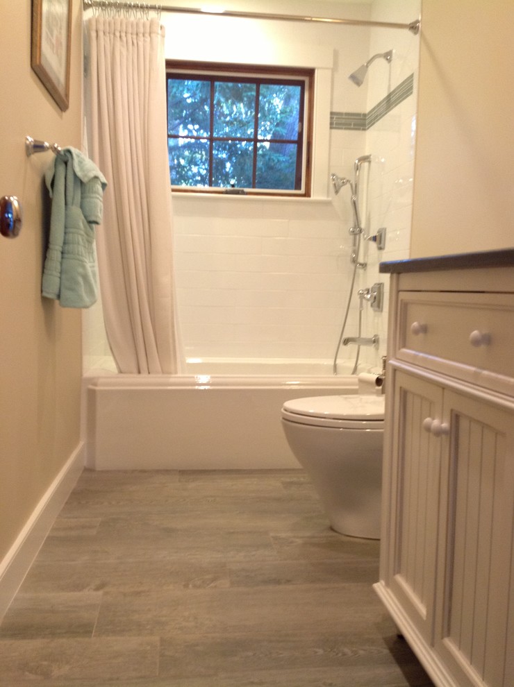 На фото: ванная комната в стиле неоклассика (современная классика) с ванной в нише, серой плиткой, плиткой под дерево и раздельным унитазом
