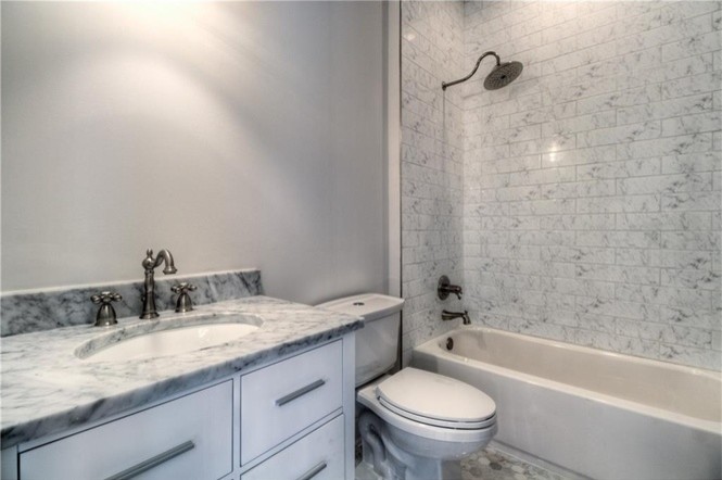 Idéer för att renovera ett mellanstort vintage badrum med dusch, med släta luckor, vita skåp, ett badkar i en alkov, en dusch/badkar-kombination, en toalettstol med hel cisternkåpa, grå kakel, vit kakel, porslinskakel, grå väggar, ett undermonterad handfat och marmorbänkskiva