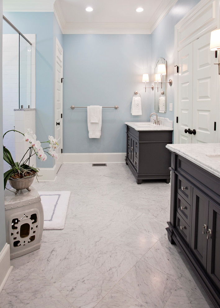 This is an example of a large classic ensuite bathroom with recessed-panel cabinets, grey cabinets, a double shower, a one-piece toilet, white tiles, ceramic tiles, blue walls, marble flooring, a built-in sink, marble worktops and a hinged door.
