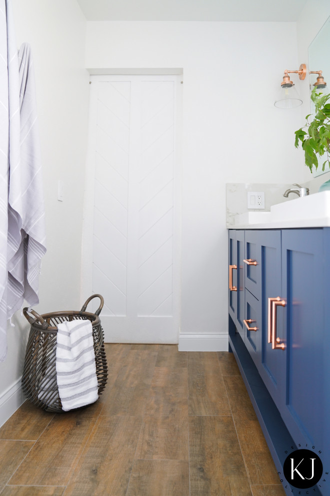 Пример оригинального дизайна: главная ванная комната среднего размера в стиле модернизм с фасадами в стиле шейкер, синими фасадами, унитазом-моноблоком, белой плиткой, белыми стенами, полом из керамогранита, коричневым полом, душем с раздвижными дверями, белой столешницей, тумбой под две раковины и встроенной тумбой