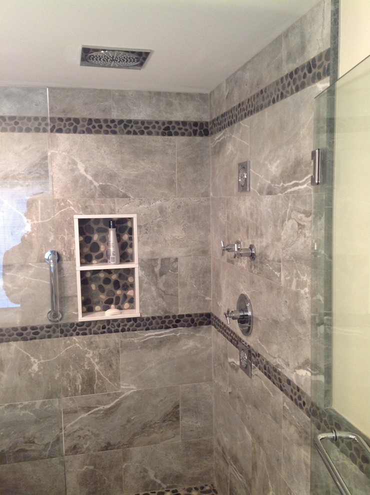 Cette photo montre une salle de bain chic avec une douche d'angle, un carrelage gris et des carreaux de porcelaine.
