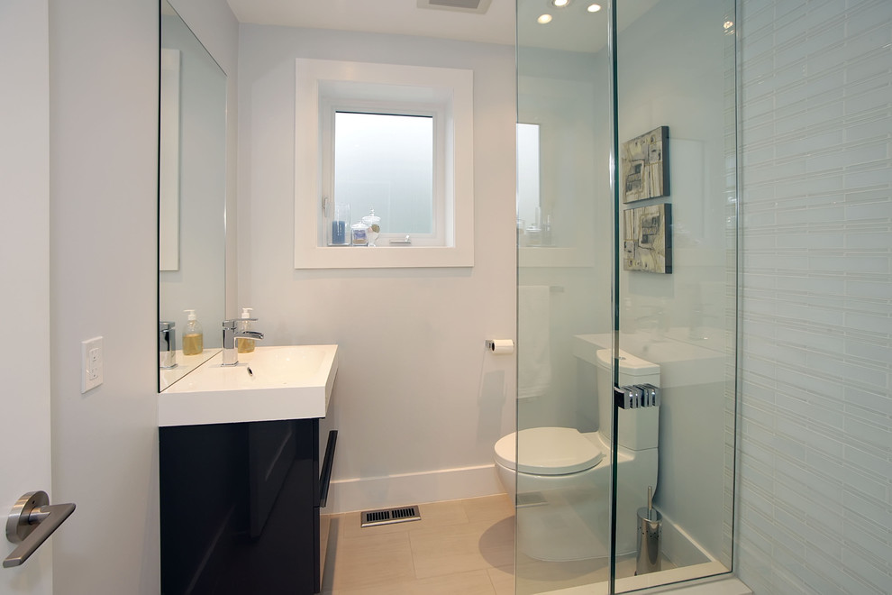 Bild på ett litet funkis badrum med dusch, med skåp i mörkt trä, en toalettstol med hel cisternkåpa, glaskakel, grå väggar, klinkergolv i keramik, släta luckor, en hörndusch, grå kakel, ett integrerad handfat, bänkskiva i kvartsit och beiget golv