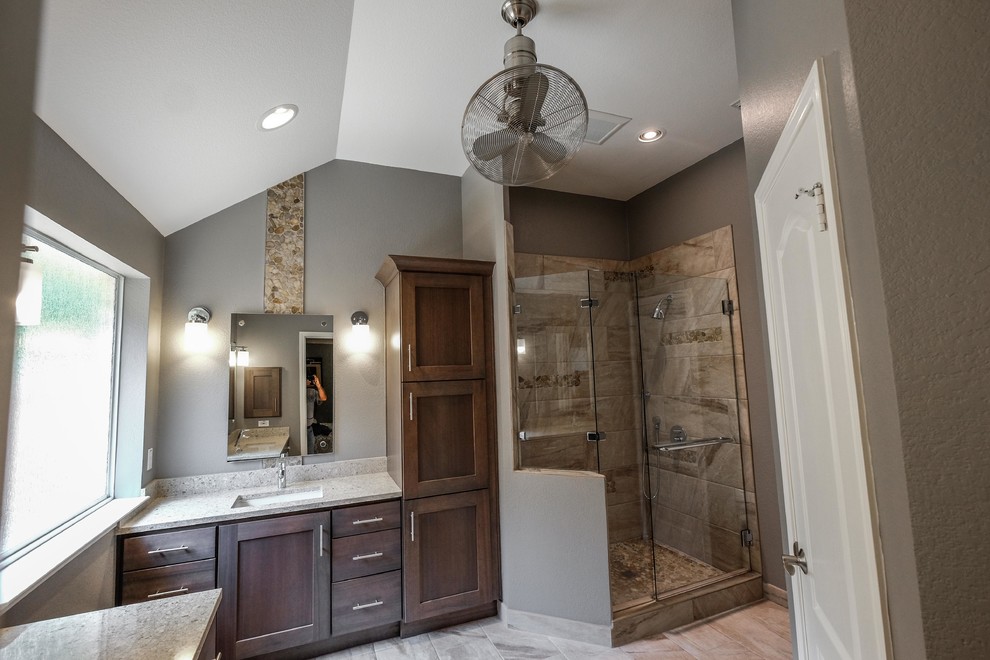 Foto de cuarto de baño principal actual de tamaño medio con armarios con paneles empotrados, puertas de armario marrones y encimera de granito