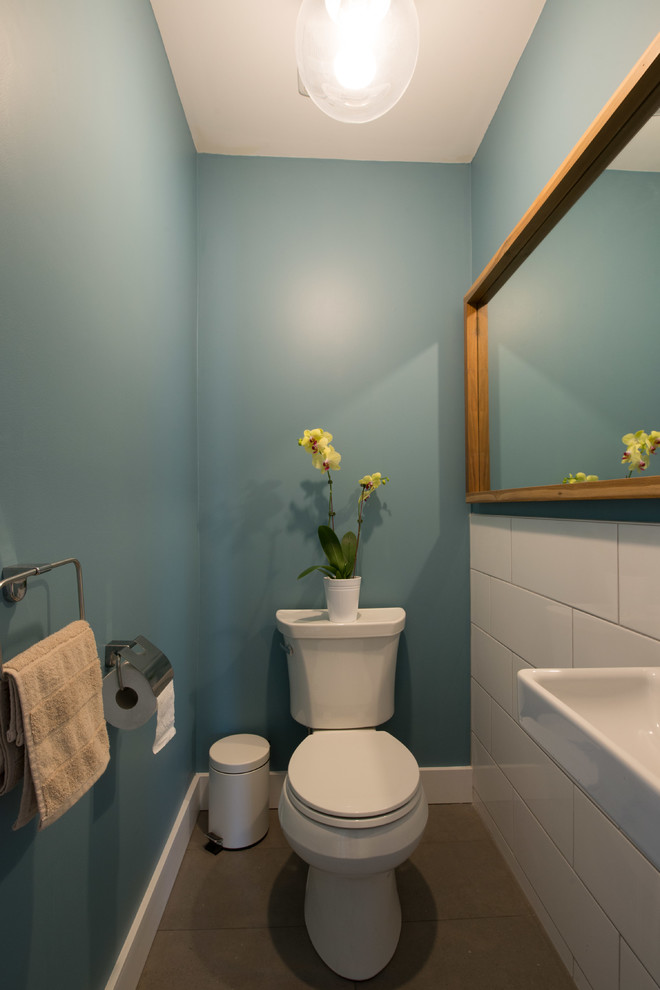 Ispirazione per una piccola stanza da bagno scandinava con WC a due pezzi, piastrelle bianche, piastrelle in ceramica, pareti blu, pavimento in gres porcellanato e lavabo sospeso