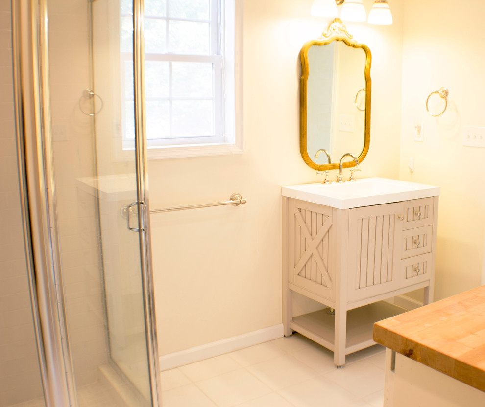 Bild på ett mellanstort funkis badrum med dusch, med skåp i shakerstil, vita skåp, en dusch i en alkov, en toalettstol med hel cisternkåpa, gula väggar, klinkergolv i keramik och ett avlångt handfat