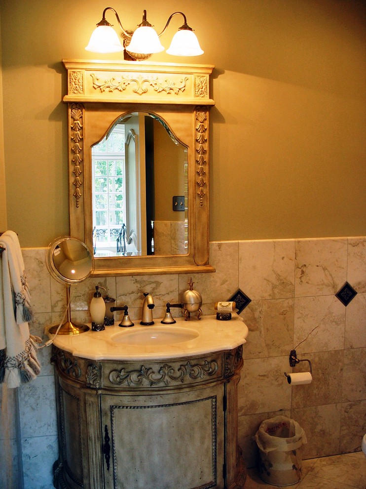 Klassisk inredning av ett mellanstort badrum med dusch, med luckor med infälld panel, skåp i slitet trä, beige kakel, grå kakel, vit kakel, porslinskakel, gula väggar, klinkergolv i porslin, ett undermonterad handfat och marmorbänkskiva
