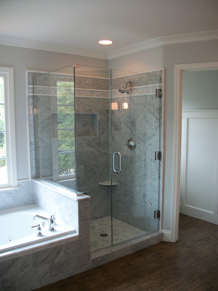 На фото: большая главная ванная комната в классическом стиле с накладной ванной, угловым душем, серой плиткой, белой плиткой, серыми стенами, темным паркетным полом, коричневым полом и душем с распашными дверями