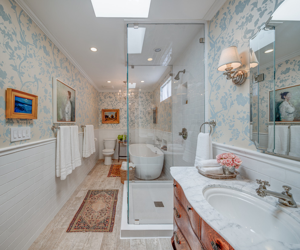 This is an example of a contemporary ensuite bathroom in Los Angeles with a built-in sink, flat-panel cabinets, medium wood cabinets, a freestanding bath, a walk-in shower, white tiles, multi-coloured walls and light hardwood flooring.