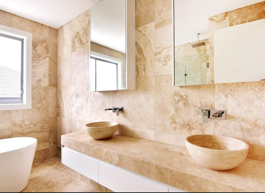 Пример оригинального дизайна: большая главная ванная комната в стиле модернизм с раковиной с несколькими смесителями, стеклянными фасадами, белыми фасадами, мраморной столешницей, отдельно стоящей ванной, угловым душем, каменной плиткой, бежевыми стенами и мраморным полом