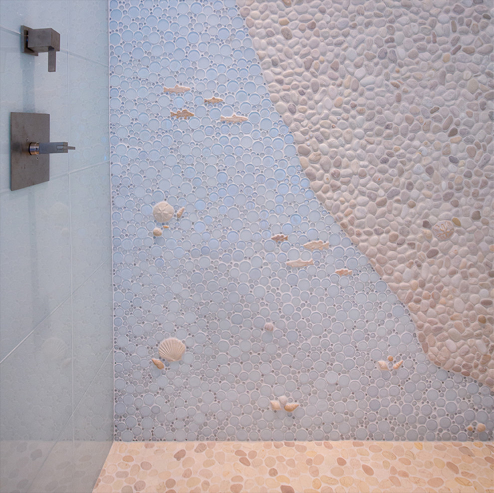 Idée de décoration pour une salle de bain marine avec un carrelage bleu, une plaque de galets et un sol en galet.