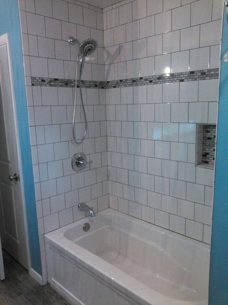 Aménagement d'une salle d'eau classique de taille moyenne avec une baignoire en alcôve, un combiné douche/baignoire, un carrelage blanc, un carrelage métro, un mur bleu, un sol en carrelage de porcelaine, un sol multicolore et une cabine de douche avec un rideau.