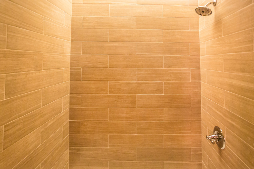 Idées déco pour une salle de bain principale contemporaine en bois clair avec un lavabo encastré, un placard à porte plane, une baignoire en alcôve, un combiné douche/baignoire, WC à poser, un carrelage beige, un carrelage métro et un mur beige.