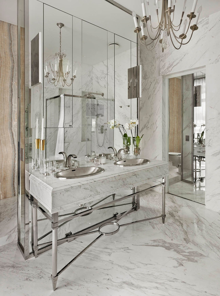 Cette photo montre une grande salle de bain tendance avec du carrelage en marbre, un sol en marbre, un plan de toilette en marbre, un mur blanc, un sol blanc, une douche d'angle et un lavabo posé.