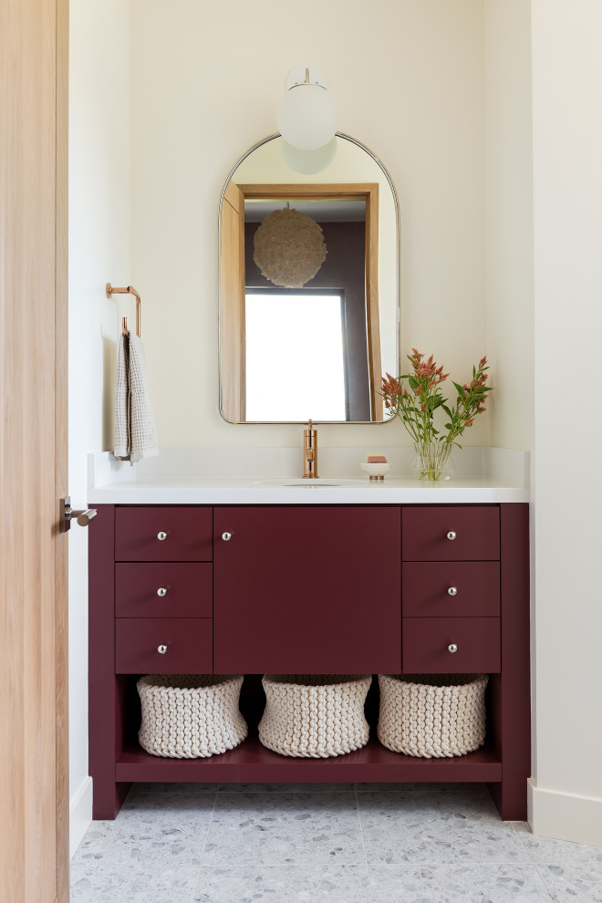 Diseño de cuarto de baño rústico con armarios con paneles lisos, puertas de armario rojas, encimera de cuarzo compacto, paredes blancas, lavabo bajoencimera, suelo gris y encimeras blancas