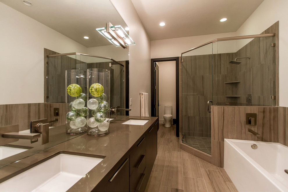 This is an example of a large contemporary ensuite bathroom in Salt Lake City with flat-panel cabinets, brown cabinets, an alcove bath, a corner shower, a two-piece toilet, brown tiles, grey tiles, ceramic tiles, beige walls, ceramic flooring, a submerged sink, brown floors and a hinged door.