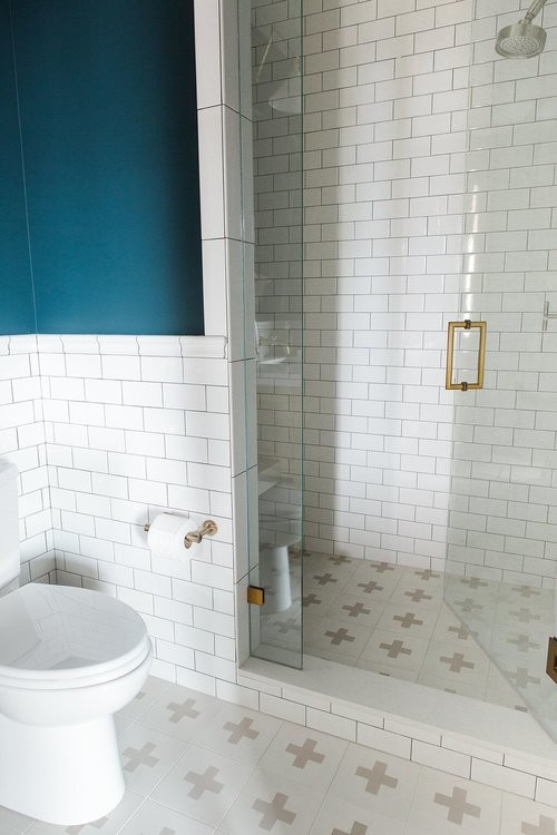 Aménagement d'une petite salle de bain éclectique avec un mur bleu, carreaux de ciment au sol, un sol multicolore et une cabine de douche à porte battante.