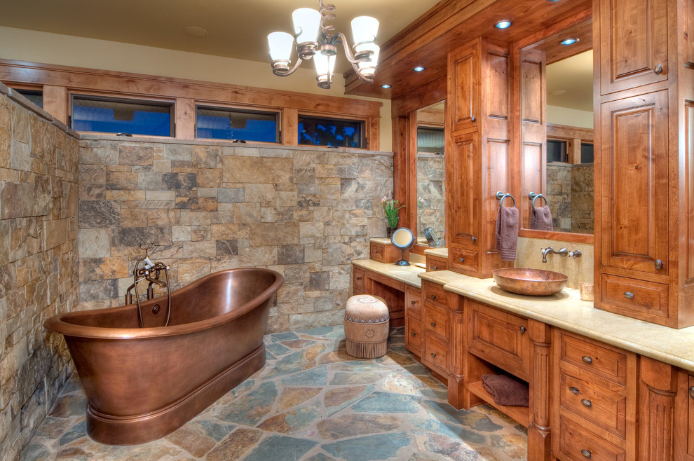 Rustik inredning av ett badrum, med ett fristående handfat, luckor med upphöjd panel, skåp i mellenmörkt trä och ett fristående badkar