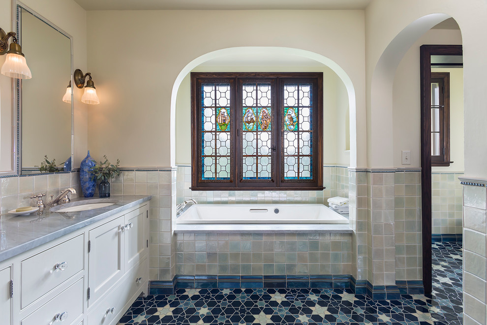 Inspiration for a timeless master multicolored tile and mosaic tile drop-in bathtub remodel in Minneapolis with white cabinets, white walls, an undermount sink and recessed-panel cabinets