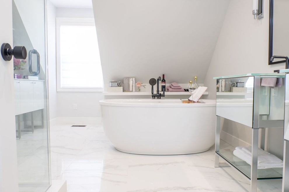 Cette photo montre une salle de bain principale chic de taille moyenne avec un placard à porte vitrée, une baignoire indépendante, une douche d'angle, un carrelage blanc, du carrelage en marbre, un mur gris, un sol en marbre, un plan de toilette en verre, un sol blanc et une cabine de douche à porte battante.