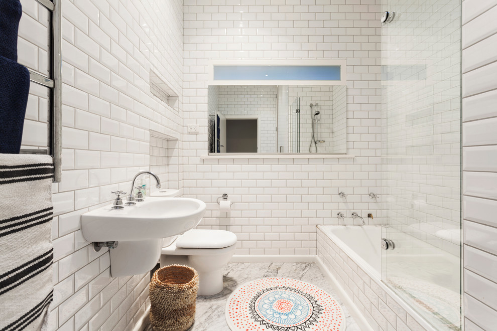 Ispirazione per una stanza da bagno design con vasca ad alcova, vasca/doccia, WC a due pezzi, piastrelle bianche, piastrelle diamantate, pareti bianche e lavabo sospeso