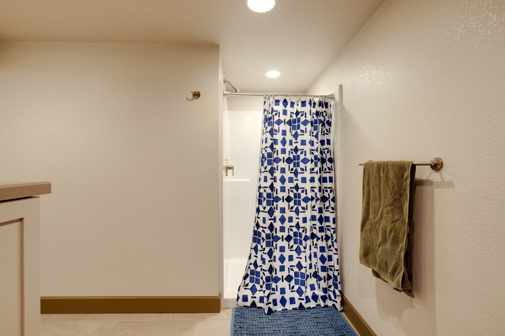 Cette image montre une salle de bain design de taille moyenne avec WC à poser, un mur beige, carreaux de ciment au sol, un lavabo de ferme, un sol beige et une cabine de douche avec un rideau.