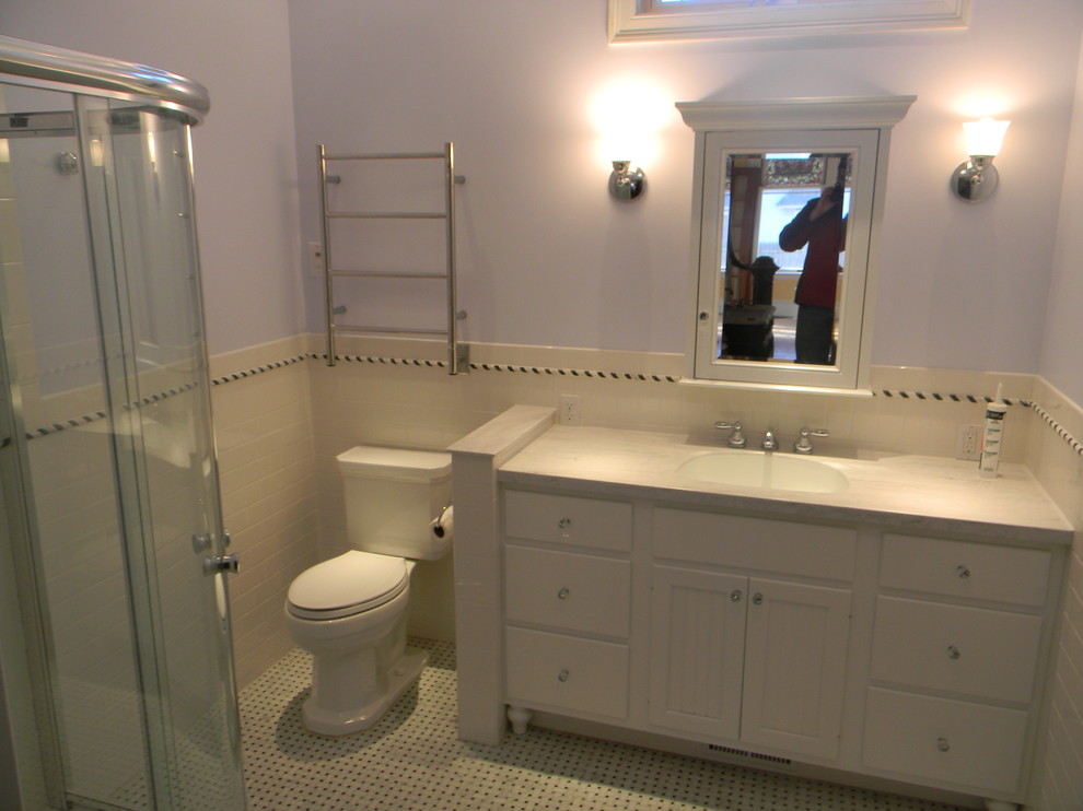 This is an example of a medium sized traditional ensuite bathroom in Providence with shaker cabinets, white cabinets, granite worktops, white tiles, ceramic tiles, a corner shower, a two-piece toilet, a built-in sink, blue walls and porcelain flooring.