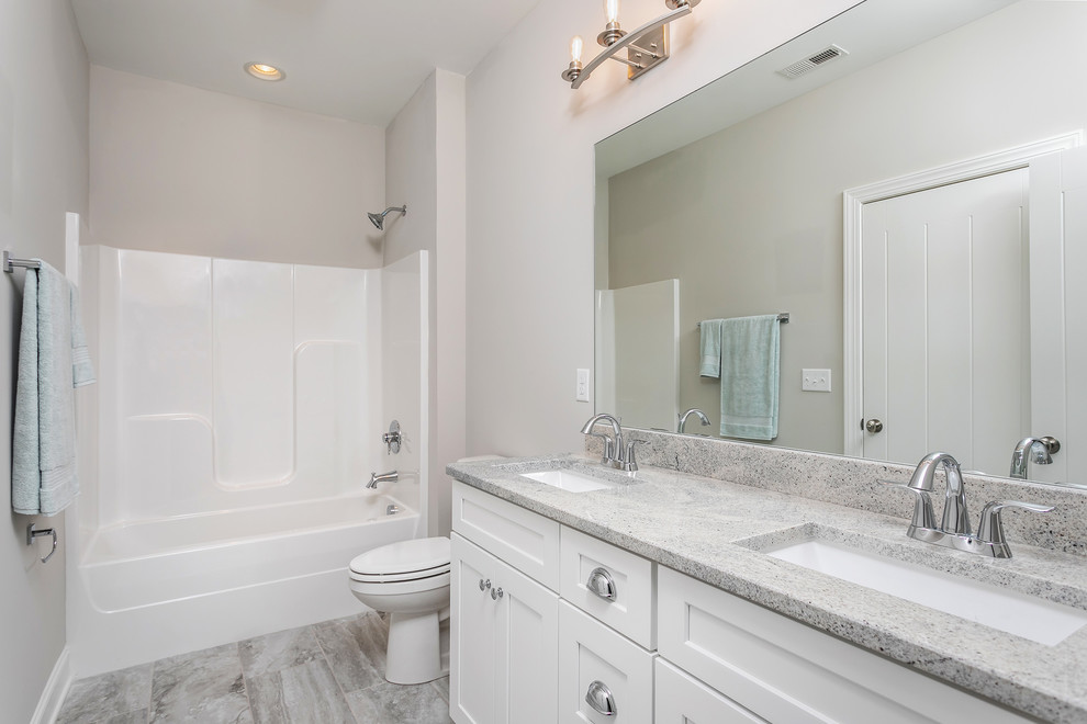 Exemple d'une petite salle de bain principale tendance avec un placard à porte shaker, des portes de placard blanches, une baignoire en alcôve, un combiné douche/baignoire, un mur beige, un sol en carrelage de porcelaine, un lavabo encastré, un plan de toilette en granite, une cabine de douche avec un rideau et un plan de toilette blanc.