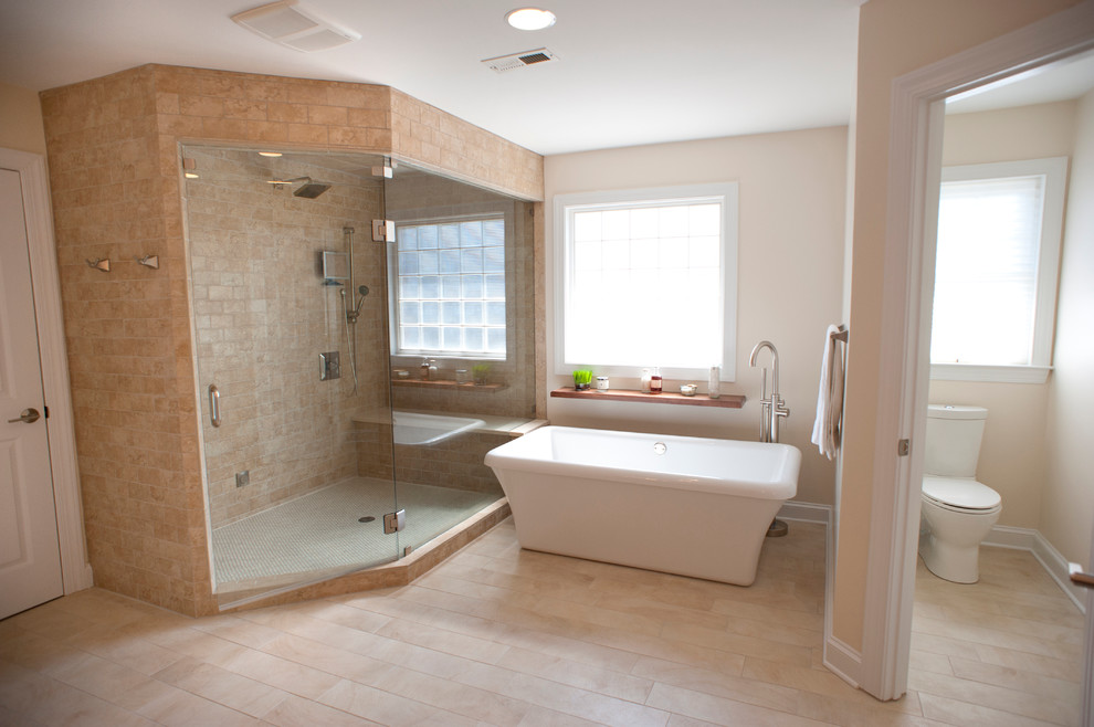 Design ideas for an expansive world-inspired ensuite bathroom in Charlotte with flat-panel cabinets, medium wood cabinets, a freestanding bath, a corner shower, a two-piece toilet, beige tiles, porcelain tiles, white walls, porcelain flooring, a vessel sink and engineered stone worktops.