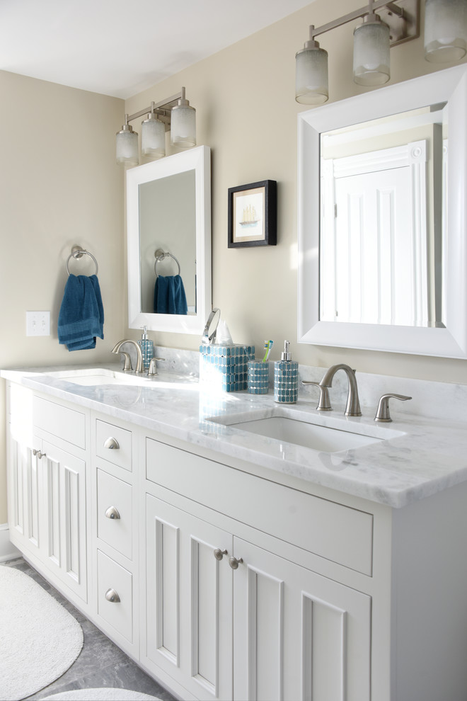 Idéer för mellanstora vintage en-suite badrum, med vita skåp, en dusch/badkar-kombination, en toalettstol med hel cisternkåpa, vit kakel, keramikplattor, beige väggar, klinkergolv i keramik, marmorbänkskiva, luckor med profilerade fronter, ett badkar i en alkov, ett väggmonterat handfat, grått golv och dusch med skjutdörr