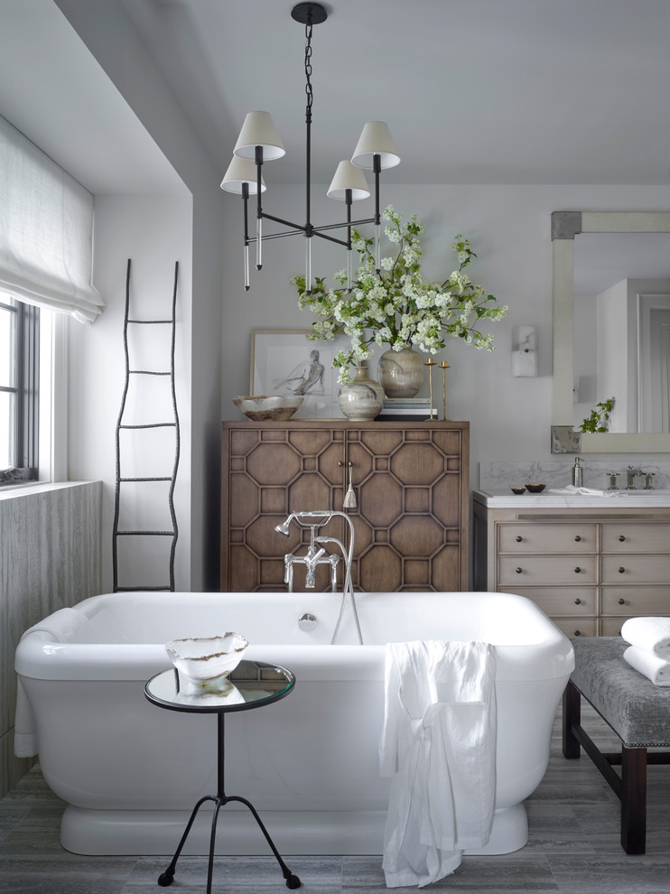 Réalisation d'une salle de bain champêtre en bois clair avec un placard avec porte à panneau encastré, un mur blanc, un sol gris et un plan de toilette blanc.
