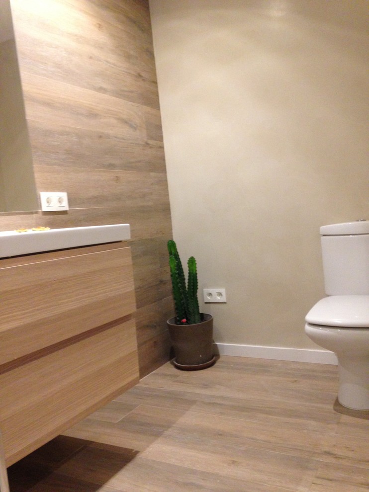 Cette image montre une petite salle d'eau minimaliste en bois brun avec un plan de toilette en bois, une douche ouverte, WC suspendus, un carrelage marron, des carreaux de céramique, un mur marron et un sol en carrelage de céramique.