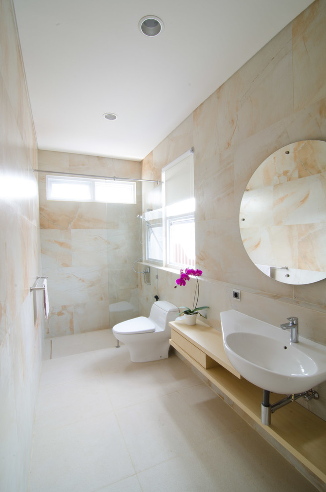 Foto på ett mellanstort orientaliskt badrum med dusch, med öppna hyllor, skåp i ljust trä, en öppen dusch, en toalettstol med hel cisternkåpa, beige kakel, stenkakel, beige väggar, ett väggmonterat handfat och laminatbänkskiva