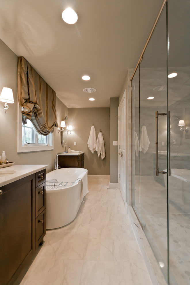 Modernes Badezimmer mit Schrankfronten im Shaker-Stil, dunklen Holzschränken, freistehender Badewanne und grauer Wandfarbe in St. Louis