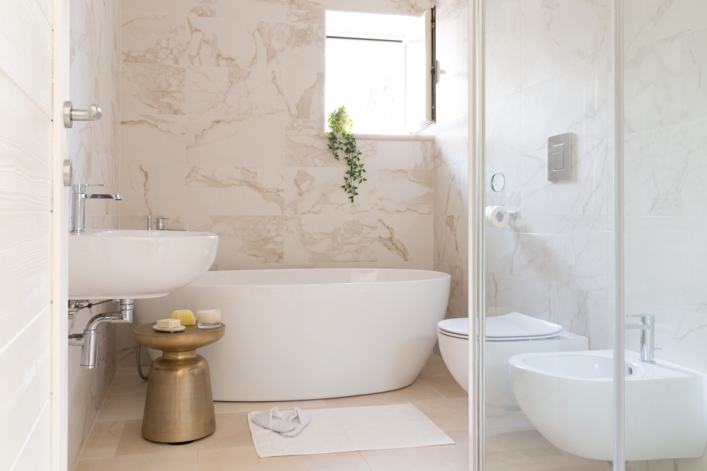 Réalisation d'une salle de bain design avec une baignoire indépendante, un carrelage blanc, un lavabo suspendu et un sol beige.