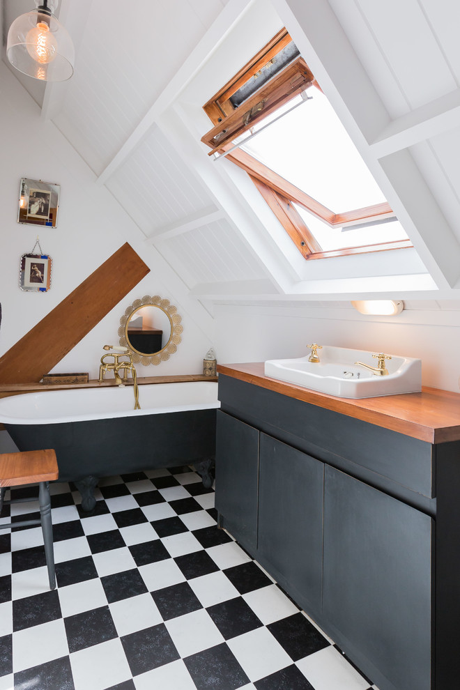 Пример оригинального дизайна: ванная комната в стиле кантри с плоскими фасадами, черными фасадами, ванной на ножках, белыми стенами, душевой кабиной, настольной раковиной и черным полом