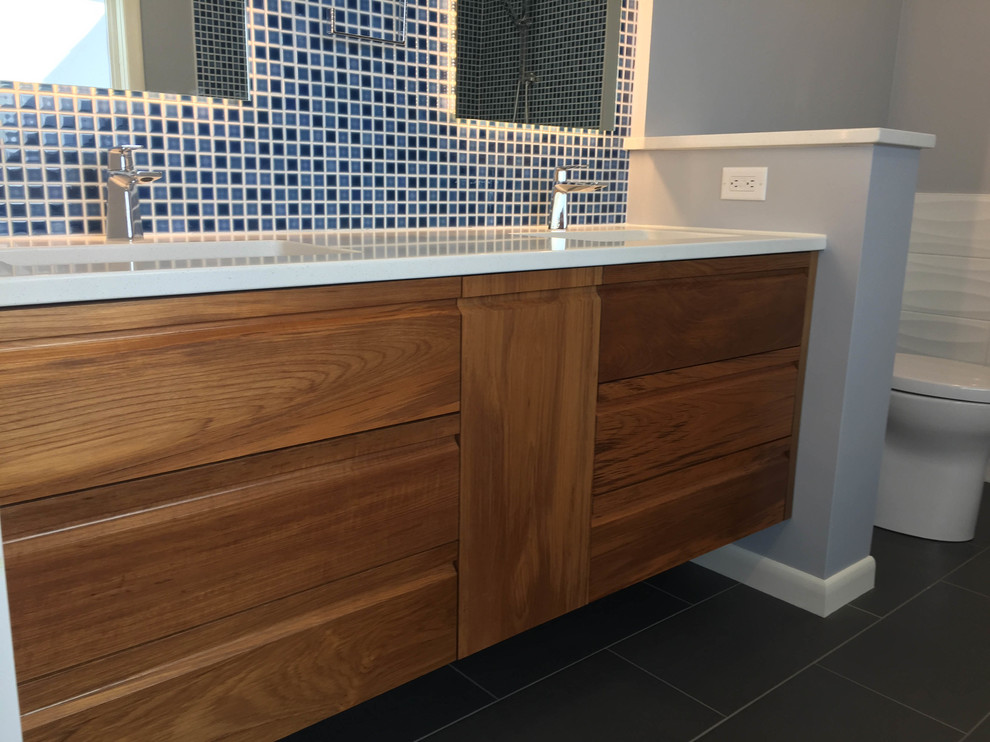 Medium sized traditional ensuite bathroom in Other with shaker cabinets, medium wood cabinets, a freestanding bath, a walk-in shower, a one-piece toilet, grey tiles, terracotta tiles, blue walls, porcelain flooring, a built-in sink, quartz worktops, grey floors and an open shower.