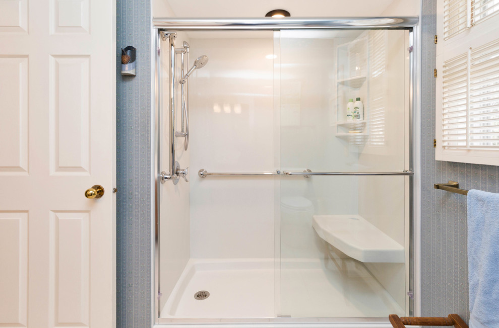 Photo of a medium sized classic bathroom in Other with raised-panel cabinets, medium wood cabinets, a corner bath, a corner shower, a one-piece toilet, white tiles, porcelain tiles, blue walls, porcelain flooring, a submerged sink, quartz worktops, white floors and a sliding door.