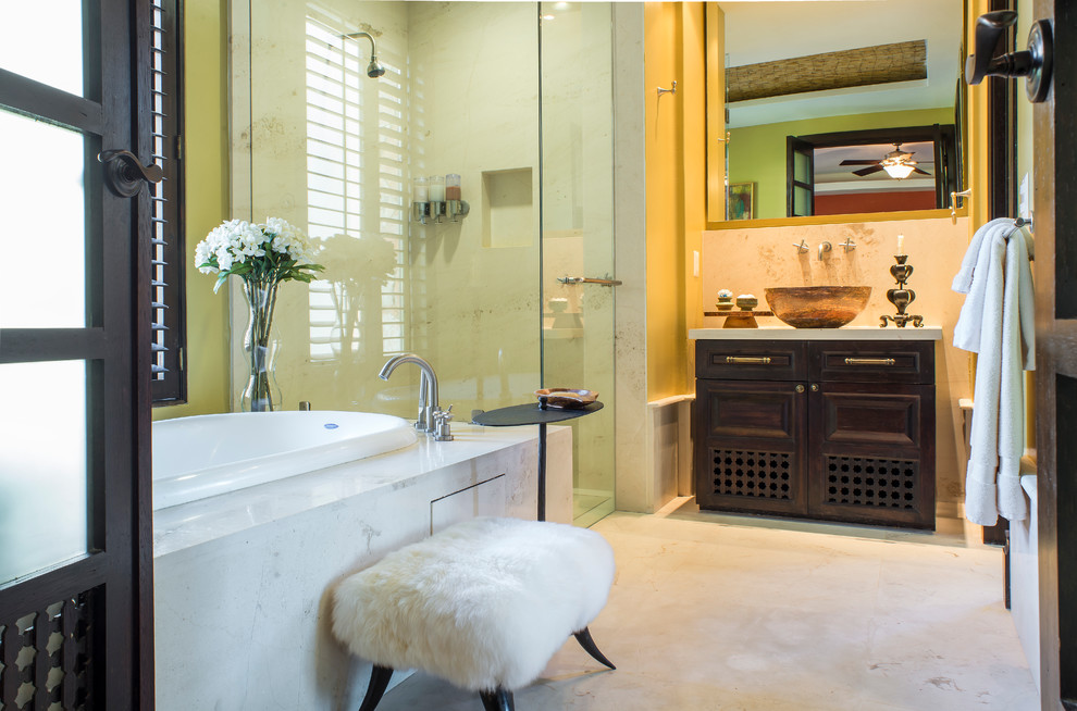 Idee per una stanza da bagno padronale tropicale di medie dimensioni con lavabo a bacinella, consolle stile comò, ante in legno bruno, top in marmo, vasca sottopiano, doccia ad angolo, pareti beige e pavimento in marmo