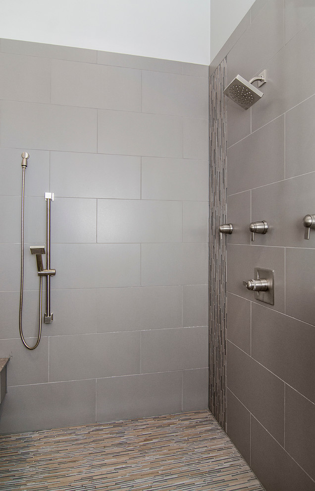 Cette photo montre une grande salle de bain principale chic en bois foncé avec une vasque, un placard à porte plane, un plan de toilette en surface solide, une baignoire indépendante, une douche d'angle, WC séparés, un carrelage gris, des carreaux de porcelaine, un mur gris et un sol en carrelage de porcelaine.