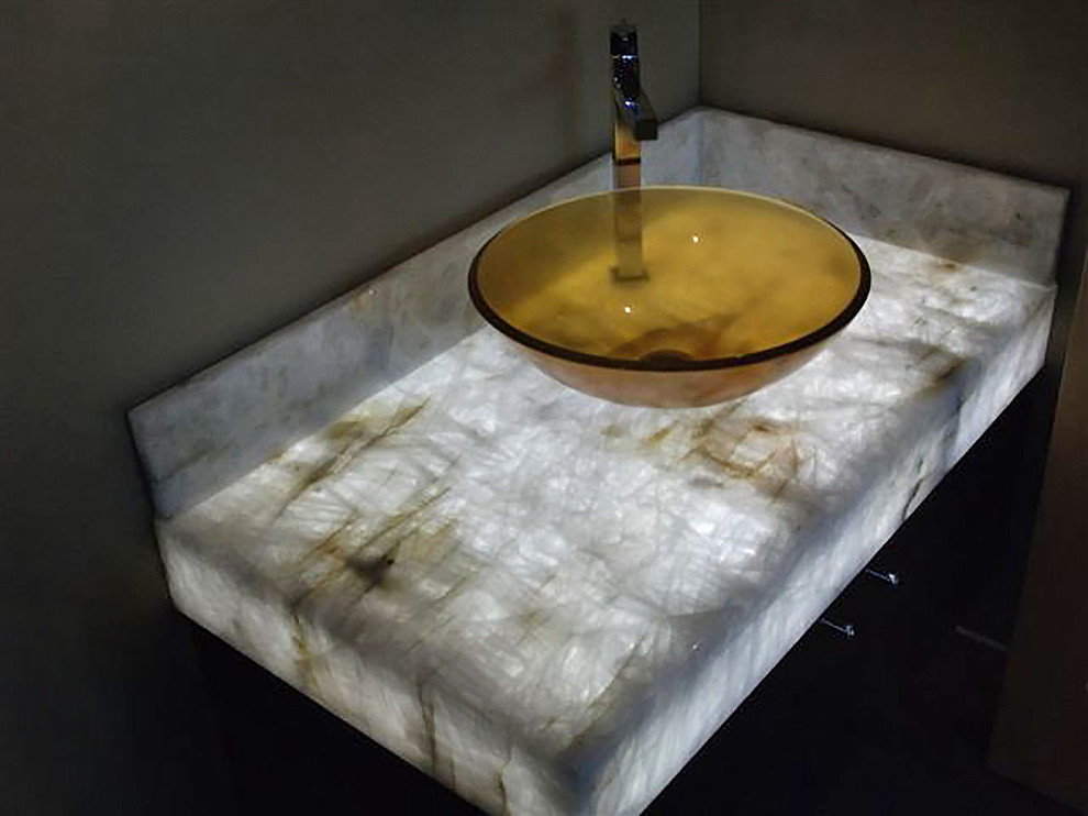 Esempio di una piccola stanza da bagno contemporanea con lavabo a bacinella, ante lisce, ante in legno bruno, top in onice e pareti beige